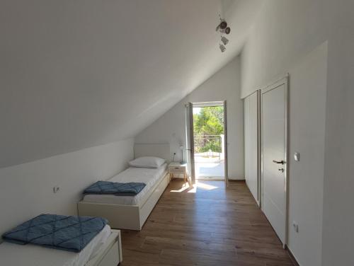 een kamer met twee bedden en een gang met een deur bij Villa Bob in Povlja