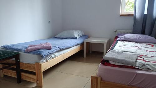 a bedroom with two twin beds and a table at noclegi na wsi ,,Ania,, in Okszów