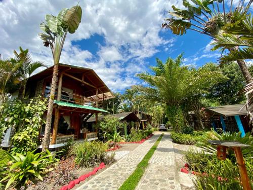 a resort with a palm tree and a building at Hostería Arasari in Mindo