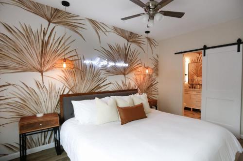 a bedroom with a white bed with a plant wall at Tropical Disco 4 Bed Pool Home Near Beach in St Petersburg