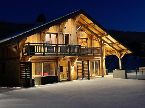a large wooden house with a balcony on it at Chalets Coeur du Lac in Malbuisson