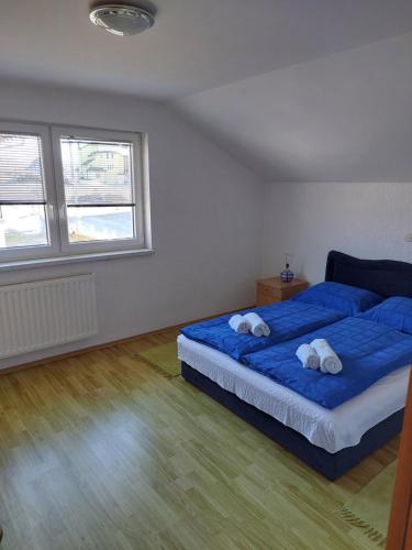 a bedroom with a blue bed with two pillows on it at Kuća Vesna in Kupres