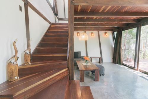 a staircase in a living room with wooden floors at Nahouse Jungle Lodges in Tulum