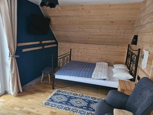 ein kleines Zimmer mit einem Bett und einem Stuhl in der Unterkunft Willa Szewcula Apartament Klimczok in Szczyrk