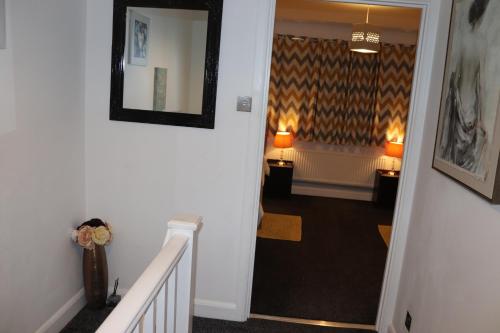 a hallway with a stairway with a mirror on the wall at Dove's Place in historic Rochester with Parking in Strood