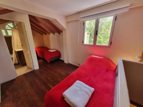 uma sala de estar com um sofá vermelho e uma cama em Cabañas Mi Lugar em Las Gaviotas