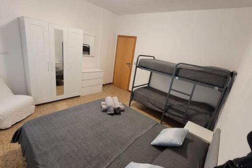 een slaapkamer met een bed en een stapelbed bij Appartamento estivo PONENTE - Misano A.(RN) in Misano Adriatico