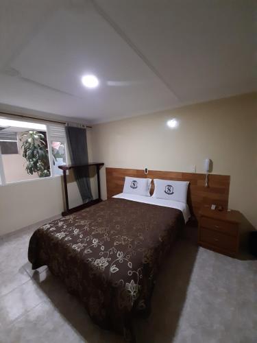 a bedroom with a bed with two pillows on it at Hotel Nuevo Siboney in Bogotá