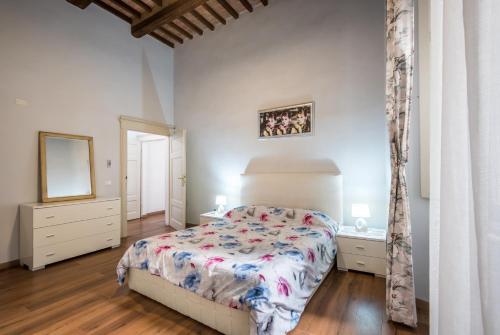 a bedroom with a bed and a mirror at Incantevole Appartamento Banchi di Sopra in Siena