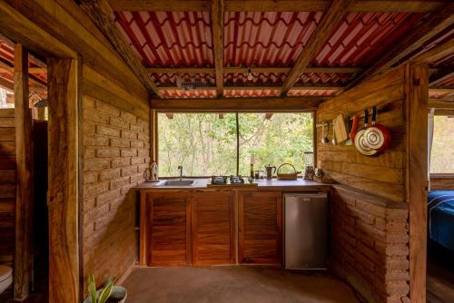 una cocina en una cabaña de madera con fregadero y ventana en Yoo'Nashi - Estancia Ecológica y Experiencias Comunitarias en Santa María Huatulco