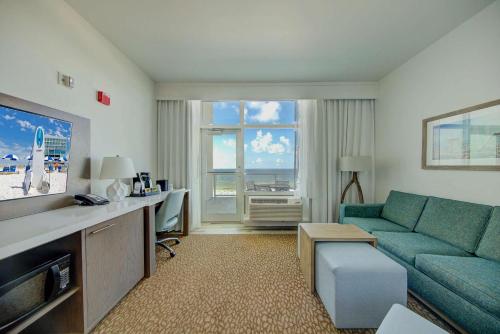 a living room with a couch and a tv at Best Western Premier - The Tides in Orange Beach