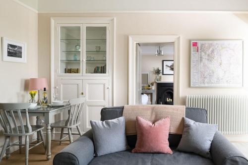 - un salon avec un canapé bleu et des oreillers roses dans l'établissement Pendle View Apartment, à Settle