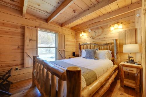 1 dormitorio con 1 cama en una cabaña de madera en Branson Antlers Lodge Cabin with Private Hot Tub en Branson