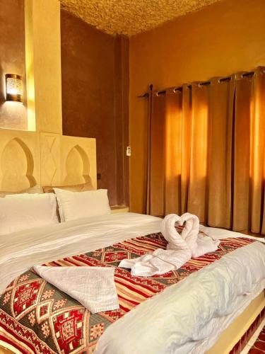 a hotel room with two beds with towels on them at Dar Hassi Labied Merzouga in Hassilabied