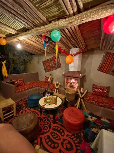 a living room with a couch and a fire place at Dar Hassi Labied Merzouga in Hassilabied