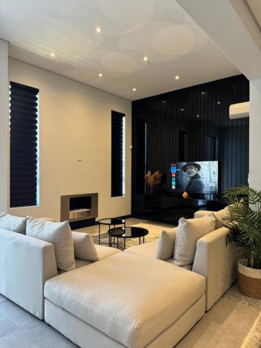 a living room with a couch and a tv at Phoenix Home in Cape Town