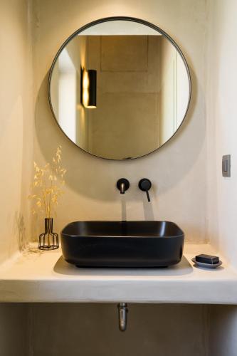 a bathroom with a black sink and a mirror at Apeiron Villas in Kefallonia