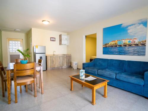 a living room with a blue couch and a table at DeLynne Resort Curaçao in Willemstad