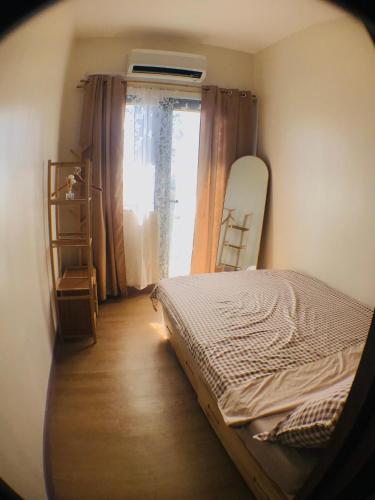 1 dormitorio con cama y ventana con tabla de snowboard en Spring Residences Affordable Staycation Bicutan Paranaque near NAIA Airport, en Manila