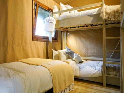 a bedroom with two bunk beds and a window at Safaritent in Ingen