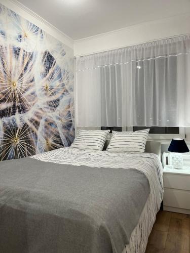 Apartament Rubinowy في تورون: غرفة نوم مع سرير مع جدار من الهندباء
