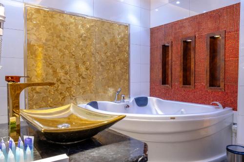 La salle de bains est pourvue d'une grande baignoire et d'un lavabo. dans l'établissement Nersyan Taiba Hotel Apartments, à Médine