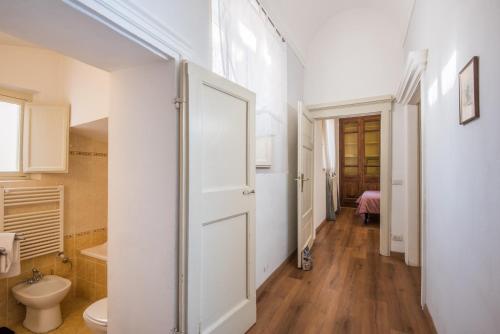 a bathroom with a white door and a toilet at Incantevole Appartamento Banchi di Sopra in Siena