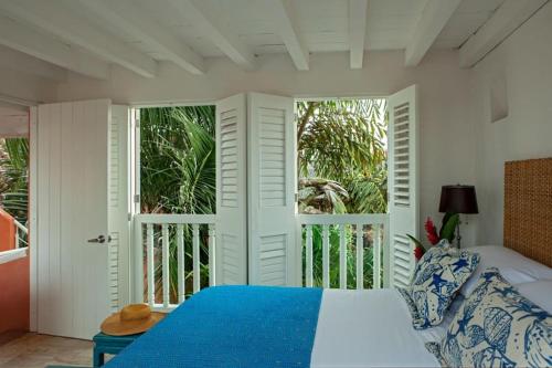 ein Schlafzimmer mit einem blauen Bett und einem Balkon in der Unterkunft Luxury 10 BR Colonial Mansion in Cartagena de Indias