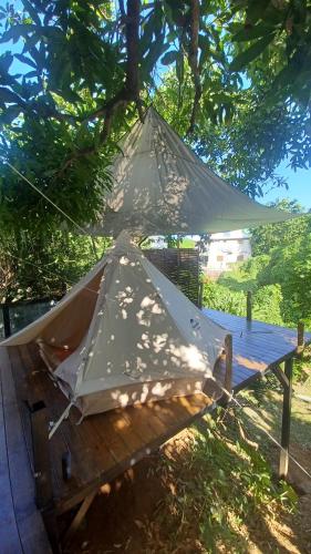 卡佩斯特雷貝勒奧的住宿－Tipi/Glamping，坐在树下野餐桌上的帐篷