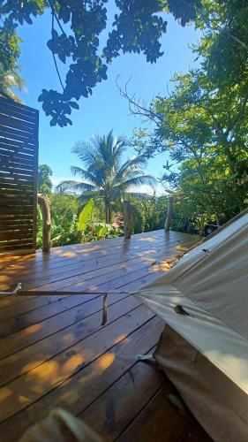 a wooden deck with a umbrella on top of it at Tipi/Glamping in Capesterre-Belle-Eau