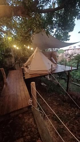 卡佩斯特雷貝勒奧的住宿－Tipi/Glamping，树下木甲板上的帐篷