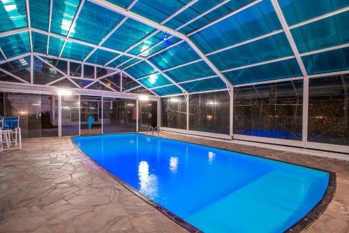 una gran piscina con techo de cristal en Pousada das Videiras en Monte Verde