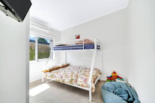 1 dormitorio con litera y ventana en The perfect Cheltenham escape - 3 bedroom house, en Cheltenham