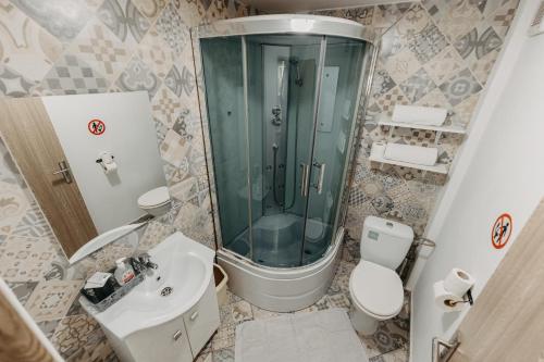 y baño con ducha, aseo y lavamanos. en Studio Piata Amzei NR.1 (8 C), en Bucarest