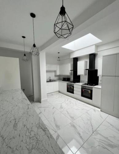 a large white kitchen with black and white appliances at The Luxury Inn 02 in Birmingham