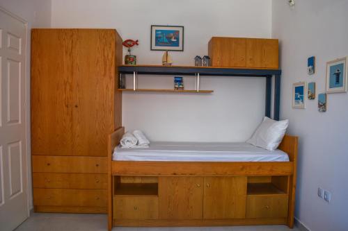 a bed in a room with a wooden bed frame at Aegean Aura Apartment III in Kalymnos