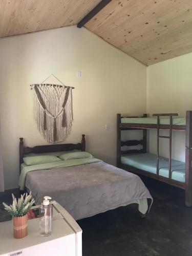 a bedroom with two bunk beds and a table at Chalé da Mata in São Roque de Minas