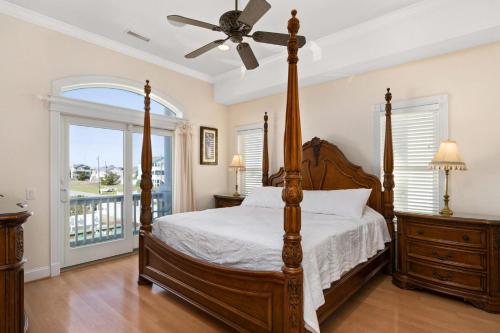 Un dormitorio con una cama y un ventilador de techo. en Imperial Palace 12 Bedroom Oceanfront Home, en Kill Devil Hills