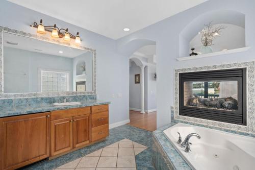 y baño con chimenea y bañera. en Imperial Palace 12 Bedroom Oceanfront Home, en Kill Devil Hills
