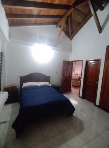 1 dormitorio con 1 cama azul en una habitación en Posada de Zory, en Santo Domingo de los Colorados