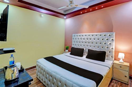 OYO Home Picturesque Stay في دهرادون: غرفة نوم بسرير كبير في غرفة