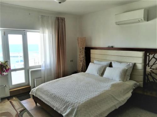 a bedroom with a bed and a large window at Belaya Udacha in Odesa