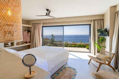 Schlafzimmer mit einem Bett und Meerblick in der Unterkunft Apeiron Villas in Kefalonia