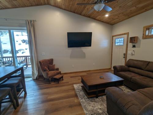 uma sala de estar com um sofá e uma mesa em Cozy Cottage 2BD/2BA, 2 Covered Decks, Patio Dinning, Newly Built! em Pinetop-Lakeside