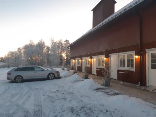 a car parked outside of a building in the snow at Närebo Gårdshotell & Restaurang in Lidköping