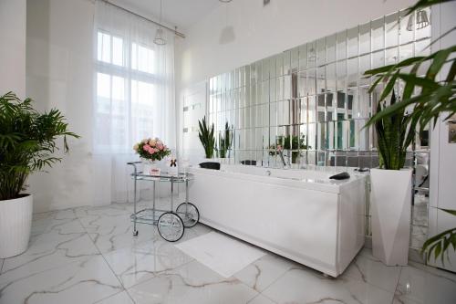 biała łazienka z wanną i roślinami w obiekcie Apartament Silver SAUNA&JACUZZI Poznań Stare Miasto w Poznaniu