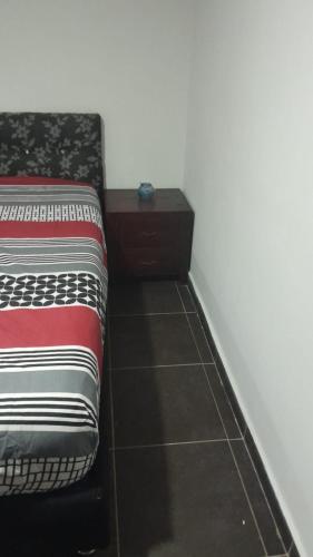 a bedroom with a bed and a nightstand next to it at El Encanto III - ApartaSuite in Barranquilla