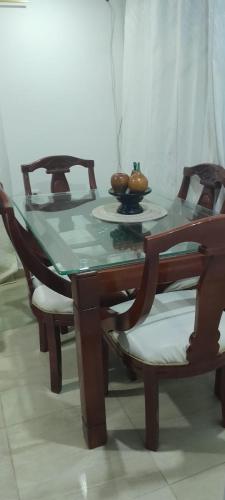 a wooden table with two chairs and a bowl of fruit on it at El Encanto III - ApartaSuite in Barranquilla