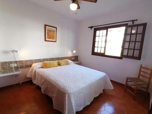 a bedroom with a bed and a window at Apartamento colibrí in Alaior