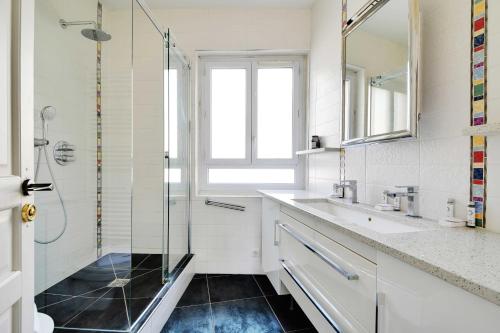 une salle de bain avec une douche en verre et un lavabo dans l'établissement Chic apartment 2BR-6P - Trocadero-Eiffel Tower, à Paris